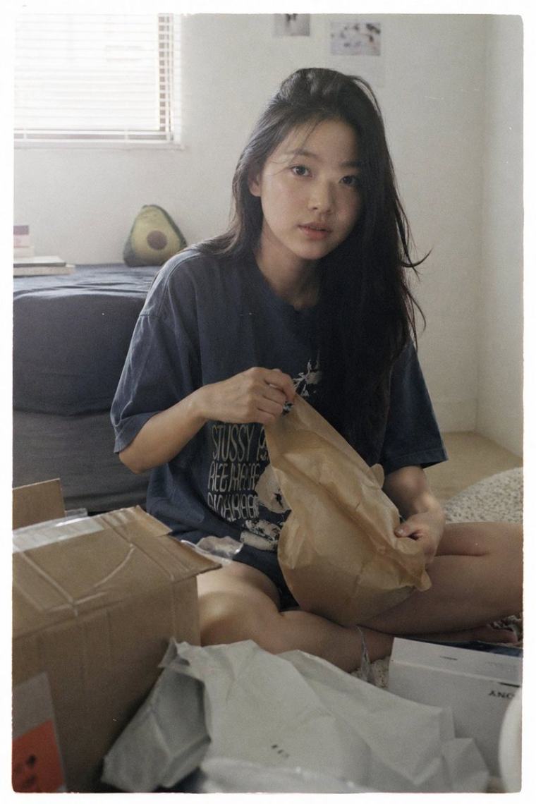 少女坐在地板上拆包裹的日常瞬间