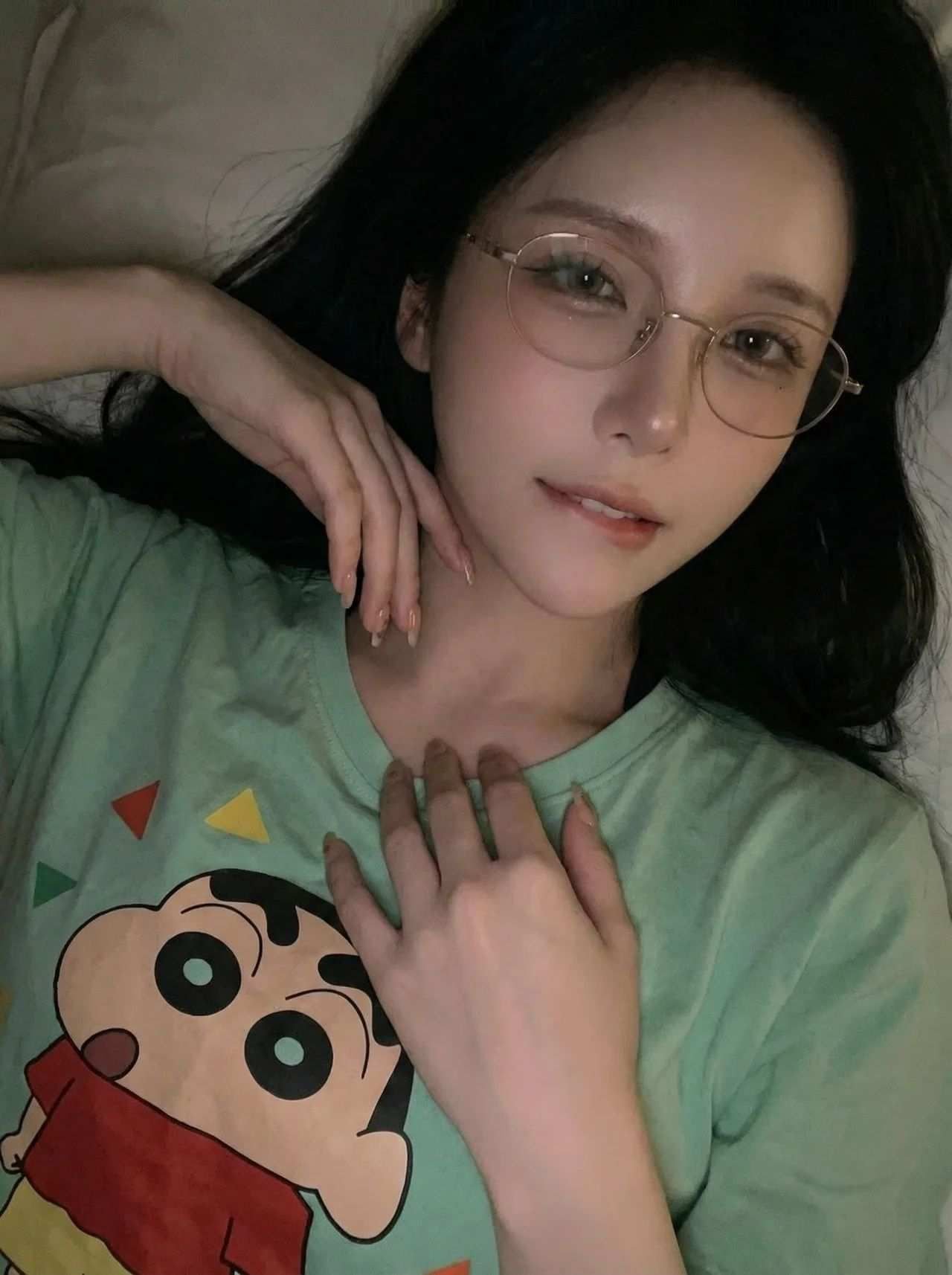 戴金丝眼镜穿蜡笔小新T恤的仰卧少女