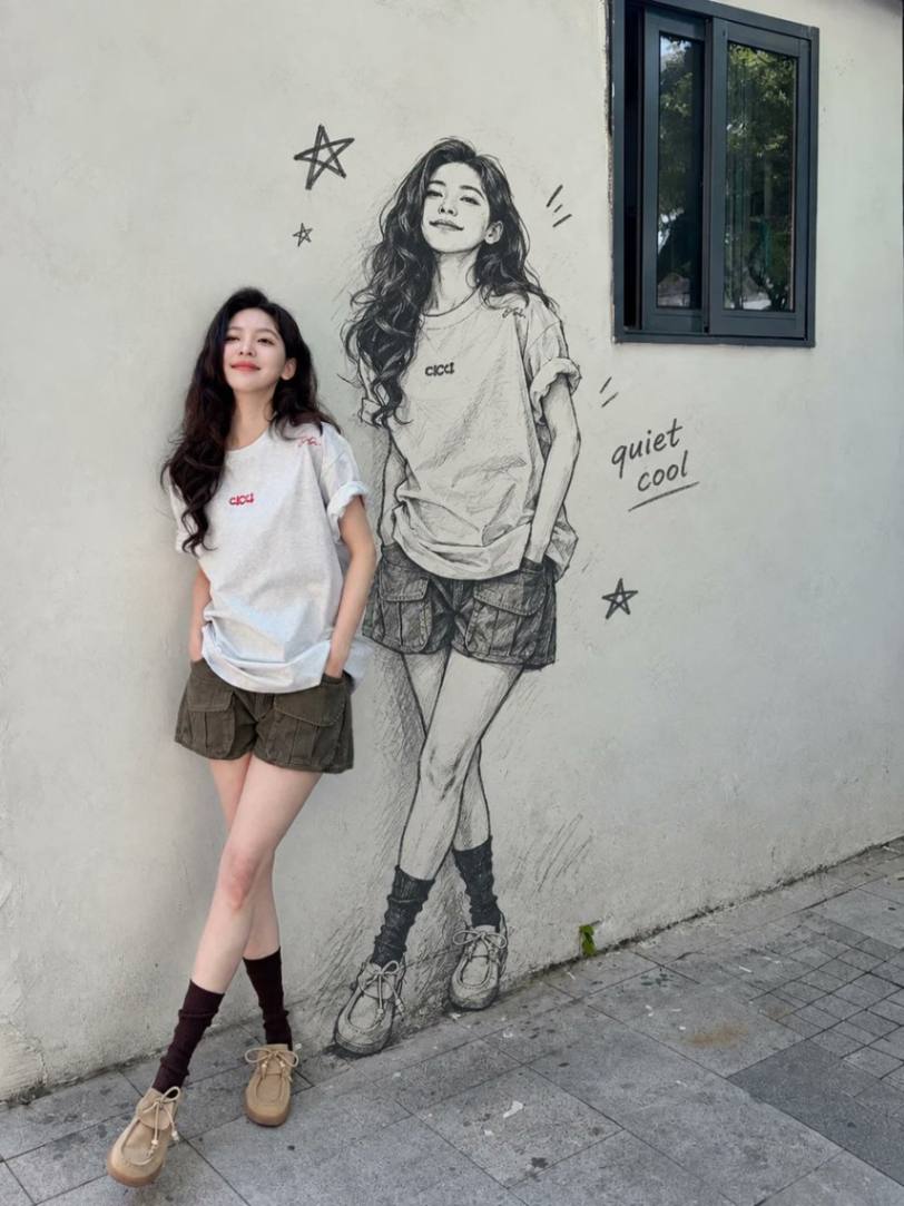 女子与墙面手绘肖像壁画合影