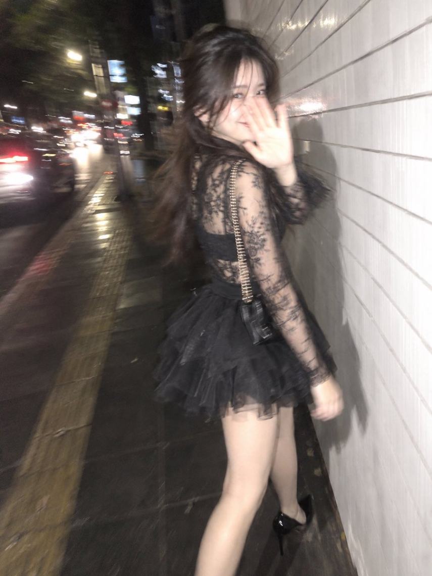 夜晚街头女子回眸抬手抓拍瞬间